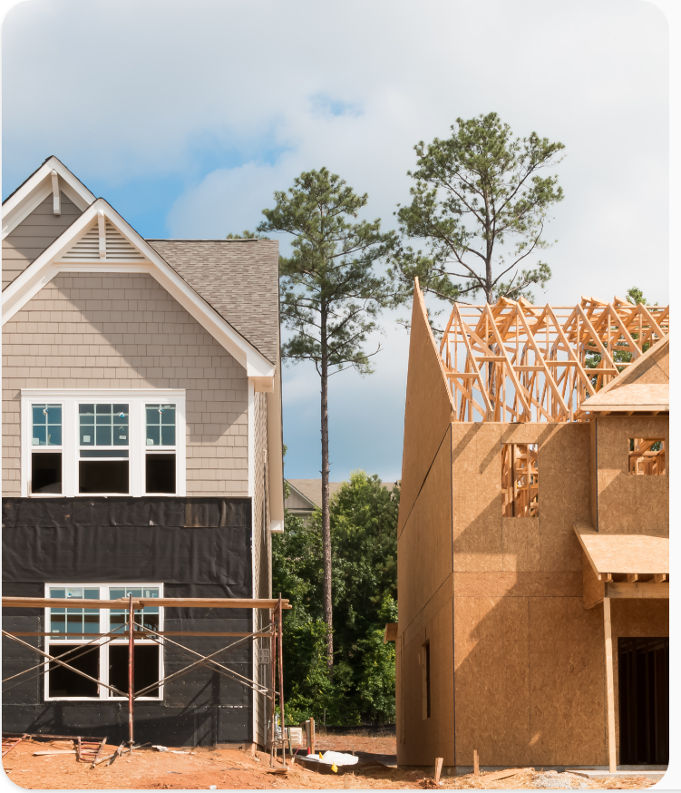 A finished home beside one still being framed